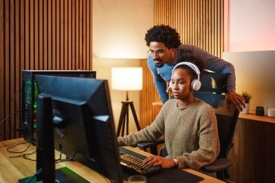 Young woman with headphones playing a game at a desk